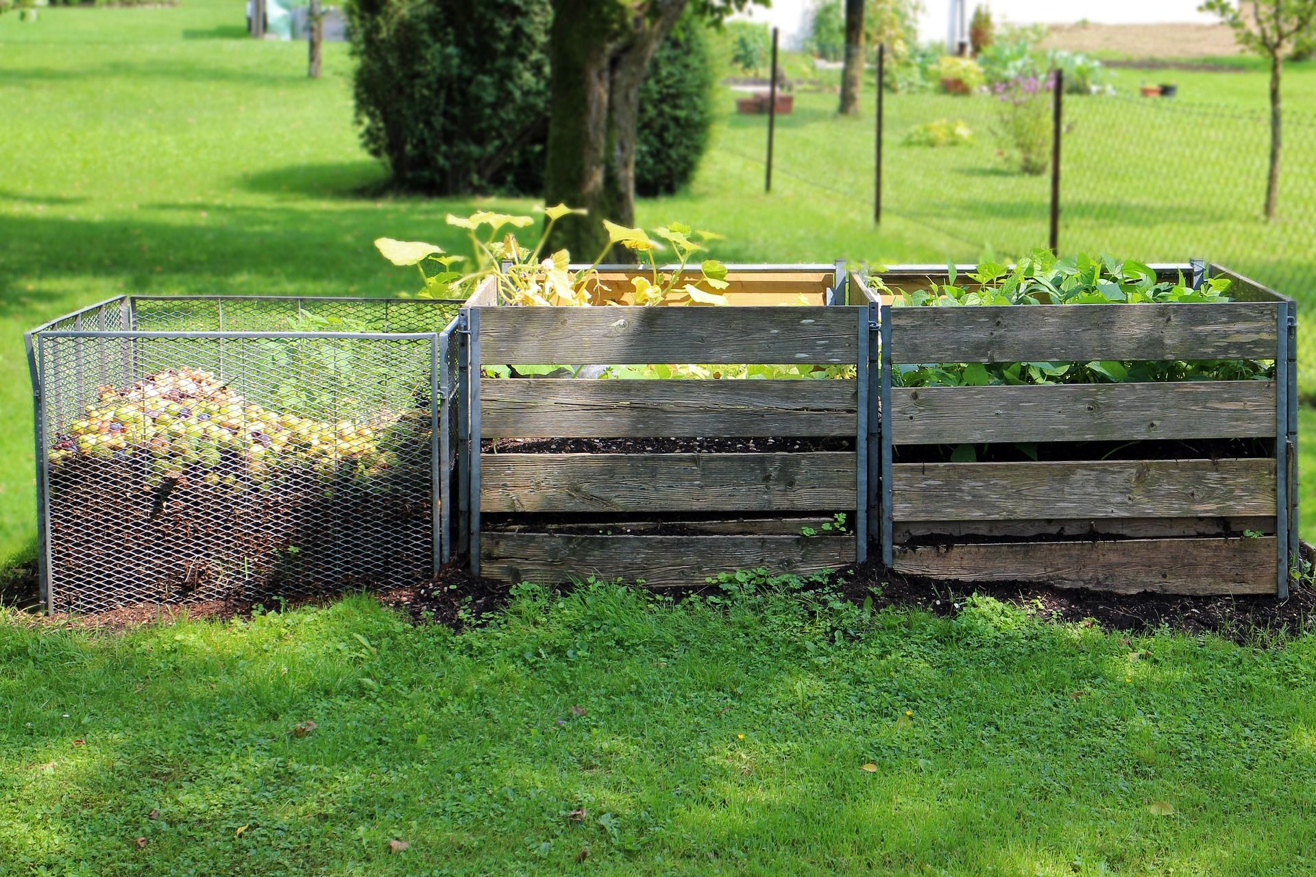 Three types of compost bin outside in a garden