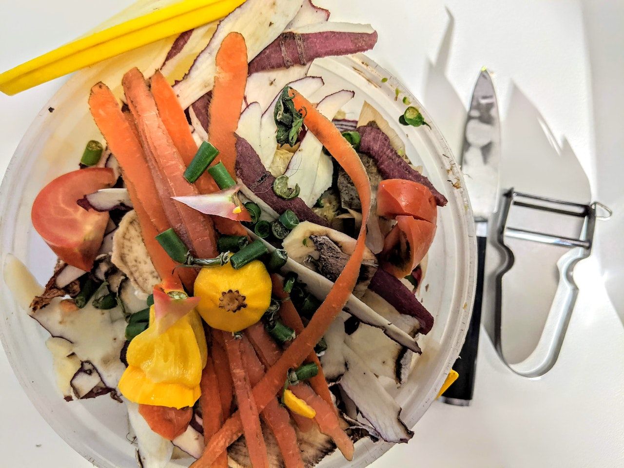 A top-down shot of a kitchen compost bin full of vegetable peelings